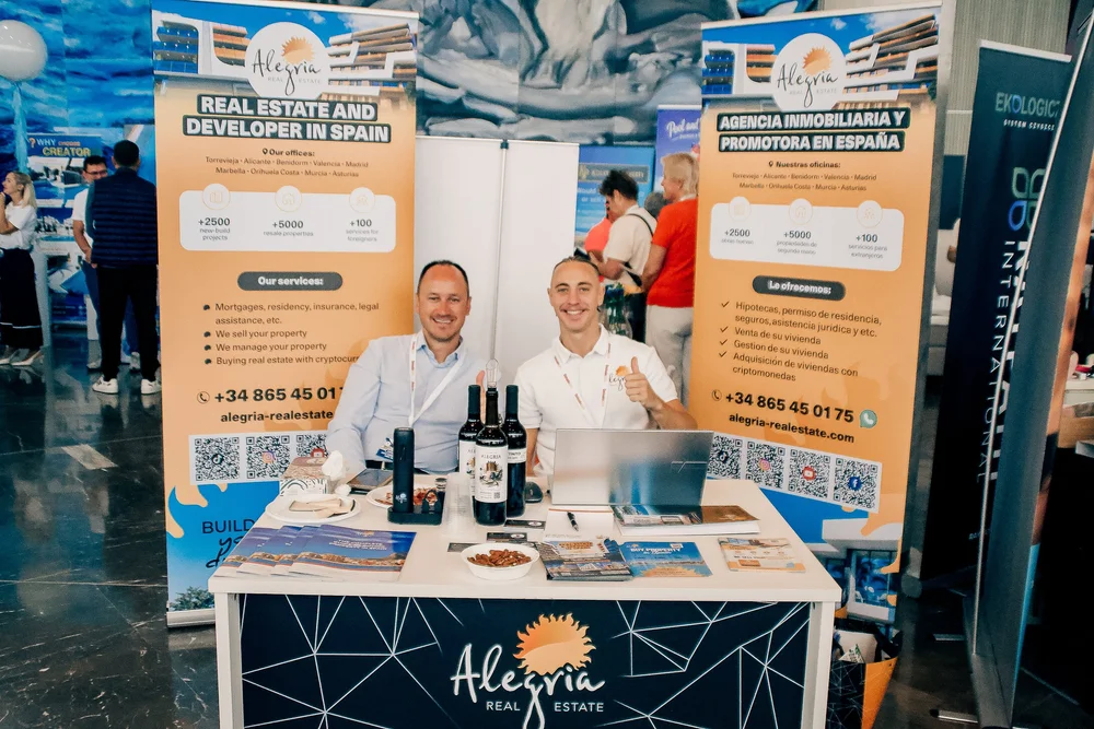 Alegria Real Estate stand with company representatives and property brochures