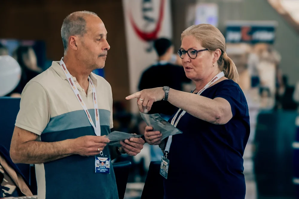 Exhibitors collaborating and exchanging brochures on the exhibition concourse