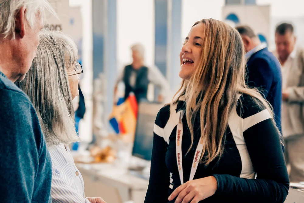 Friendly exhibitor smiling and consulting with interested visitors